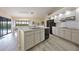 Modern kitchen featuring a central island, stainless steel appliances, and views of the outdoor pool at 3936 Crooked Island Dr, Punta Gorda, FL 33950