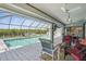 Screened-in pool with waterfront view, seating area, and tiled patio for relaxing and entertaining outdoors at 3936 Crooked Island Dr, Punta Gorda, FL 33950