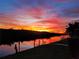 Stunning sunset view of the waterfront property, showcasing a private dock and serene canal ambiance at 3936 Crooked Island Dr, Punta Gorda, FL 33950