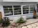 Exterior view with large windows, landscaping, rock garden and partial view of adjacent fence at 405 Bryn Mawr Is, Bradenton, FL 34207