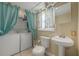 Bathroom including toilet, sink, and combined washer/dryer with curtains at 4100 Miramar Way, St Petersburg, FL 33705