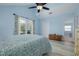 Bright main bedroom features light blue walls, a ceiling fan, walk-in closet and view to the ensuite bathroom at 4100 Miramar Way, St Petersburg, FL 33705