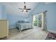 Bright main bedroom features light blue walls, a ceiling fan and a sliding glass door leading to a balcony at 4100 Miramar Way, St Petersburg, FL 33705