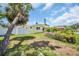 A sunny back yard and yellow exterior is surrounded by a white fence and lush greenery at 4200 49Th S Ave, St Petersburg, FL 33711