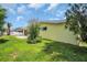 Sunny backyard featuring a yellow exterior, green grass, and some trees at 4200 49Th S Ave, St Petersburg, FL 33711