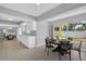Modern kitchen and dining area with white cabinets, contemporary table setting, and natural light at 4200 49Th S Ave, St Petersburg, FL 33711