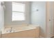 Bright bathroom with a soaking tub, window, and neutral wall paint at 4264 Michaler St, North Port, FL 34286
