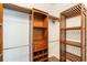 Walk-in closet featuring custom wooden shelving, ample storage space, and hardwood floors at 4264 Michaler St, North Port, FL 34286