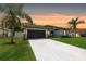 Charming single-story home with a well-manicured lawn, palm trees, and a freshly painted driveway at 4264 Michaler St, North Port, FL 34286