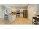 Well-lit kitchen features stainless steel appliances, breakfast bar, and tile floors at 4264 Michaler St, North Port, FL 34286