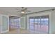 Neutral bedroom with ceiling fan, glass doors, tile flooring, and an open doorway at 4823 Arlington Rd, Palmetto, FL 34221