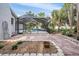 An outdoor patio with garden and a glimpse of the screened-in swimming pool and well-maintained landscaping at 6411 Barton Rd, Plant City, FL 33565