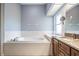 Bathroom featuring a soaking tub, tile floors, and a granite-topped vanity at 6411 Barton Rd, Plant City, FL 33565