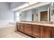 Well-lit bathroom featuring double sinks, granite countertops, and a separate soaking tub at 6411 Barton Rd, Plant City, FL 33565