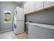 Functional laundry room with stacked washer and dryer, sink, and storage cabinets at 6411 Barton Rd, Plant City, FL 33565