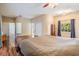 Bright main bedroom featuring wood floors, neutral walls, and an en suite bathroom at 6411 Barton Rd, Plant City, FL 33565