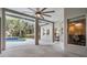 View of the screened-in patio with ceiling fan overlooking the sparkling in-ground swimming pool and lush landscaping at 6411 Barton Rd, Plant City, FL 33565