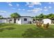 Lush backyard featuring a patio with seating and a fire pit, great for outdoor entertaining at 6551 S West Shore Cir, Tampa, FL 33616
