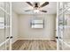 Bright bedroom with a ceiling fan, hardwood floors, and stylish French doors to the ensuite at 6551 S West Shore Cir, Tampa, FL 33616