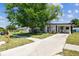 Charming single-story home with a covered carport and mature trees in a landscaped front yard at 6551 S West Shore Cir, Tampa, FL 33616