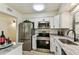Updated kitchen with stainless steel appliances, marble countertops, and wood flooring at 6551 S West Shore Cir, Tampa, FL 33616