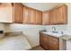 Functional laundry room with ample cabinet space, a convenient sink, and a window for natural light at 6551 S West Shore Cir, Tampa, FL 33616