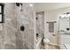 Elegant bathroom featuring a stylish shower with gray stone tiles, black hardware, and natural light from a window at 6551 S West Shore Cir, Tampa, FL 33616