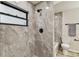 Elegant bathroom featuring a stylish shower with gray stone tiles, black hardware, and natural light from a window at 6551 S West Shore Cir, Tampa, FL 33616