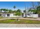 Charming single-story home boasting a beautifully landscaped yard with mature palm trees and a circular driveway at 709 Pruitt Dr, Madeira Beach, FL 33708
