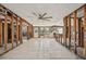 Open-concept living room in need of renovation, showcasing large windows and a modern ceiling fan at 709 Pruitt Dr, Madeira Beach, FL 33708