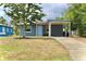 Cozy single-story home featuring a covered carport and a cheerful blue front door at 7307 34Th N Ave, St Petersburg, FL 33710