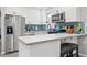 Updated kitchen with stainless steel appliances, white cabinets, and stylish tile backsplash at 7307 34Th N Ave, St Petersburg, FL 33710