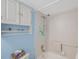Shower-tub combo showcasing white tiled walls, a handheld shower head, and extra shelving for bath accessories at 7600 Sun Island S Dr # 407, South Pasadena, FL 33707