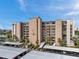 Exterior elevation of building showing parking and green spaces with palm trees at 7600 Sun Island S Dr # 407, South Pasadena, FL 33707