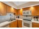 Kitchen features stainless steel sink, white appliances, and tile backsplash at 7600 Sun Island S Dr # 407, South Pasadena, FL 33707