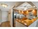 Open-concept kitchen features stainless steel appliances, wood cabinets, and a breakfast bar at 7600 Sun Island S Dr # 407, South Pasadena, FL 33707