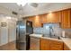 Kitchen featuring stainless steel appliances, wood cabinets, and tiled backsplash at 7600 Sun Island S Dr # 407, South Pasadena, FL 33707