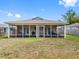A wide screened-in back porch with comfortable seating overlooks the spacious backyard with a lawn at 7712 40Th N Ter, St Petersburg, FL 33709