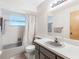 Well-lit bathroom with a combined bathtub and shower with a gray vanity at 7712 40Th N Ter, St Petersburg, FL 33709