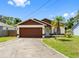 Charming single-story home with a well-maintained lawn, brown accents, and attached two-car garage at 7712 40Th N Ter, St Petersburg, FL 33709