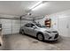 Attached garage featuring a two-car garage door, and storage shelves, accommodating a silver sedan at 7712 40Th N Ter, St Petersburg, FL 33709