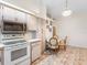 Kitchen with neutral colored cabinetry, oven, microwave, and adjacent dining area with a round table at 7712 40Th N Ter, St Petersburg, FL 33709