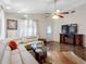Comfortable living room with large sectional, marble floors, and a decorative ceiling fan for a modern touch at 7712 40Th N Ter, St Petersburg, FL 33709
