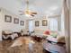 Spacious living room with unique furniture, ceiling fan, and large windows for abundant natural light at 7712 40Th N Ter, St Petersburg, FL 33709