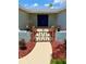 Charming front entrance, featuring a lovely walk-way, decorative gate and freshly mulched beds leading to a blue double door entry at 7831 Red Run Dr, Port Richey, FL 34668