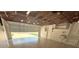 Garage with open door to driveway and unfinished ceiling at 7831 Red Run Dr, Port Richey, FL 34668