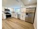 Modern kitchen with stainless steel appliances, white cabinets, and quartz countertops at 7831 Red Run Dr, Port Richey, FL 34668
