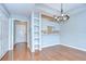 Open-concept dining area with hardwood floors, decorative chandelier, and built-in shelving at 800 S Dakota Ave # 429, Tampa, FL 33606