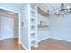 Open-concept dining area with hardwood floors, decorative chandelier, and built-in shelving at 800 S Dakota Ave # 429, Tampa, FL 33606