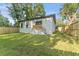 Manicured backyard with a freshly painted white home and a wooden deck and fence at 8112 N 10Th St, Tampa, FL 33604